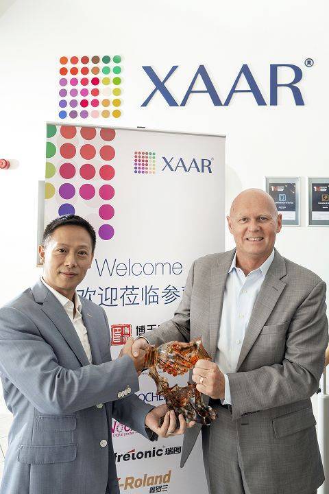 XAAR标记前两人手持工艺品合影