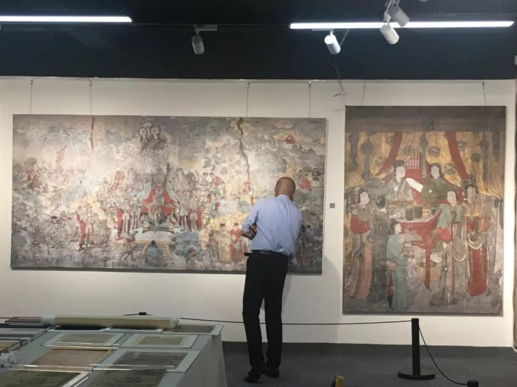 职员在展厅内审查墙面图画